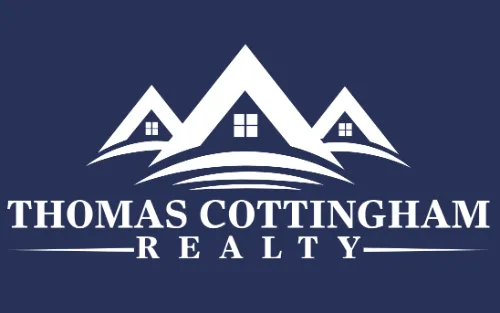 A blue and white logo of thomas cottingham realty