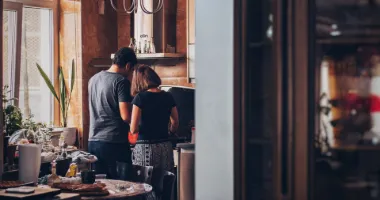 A man and woman standing in front of an oven.
